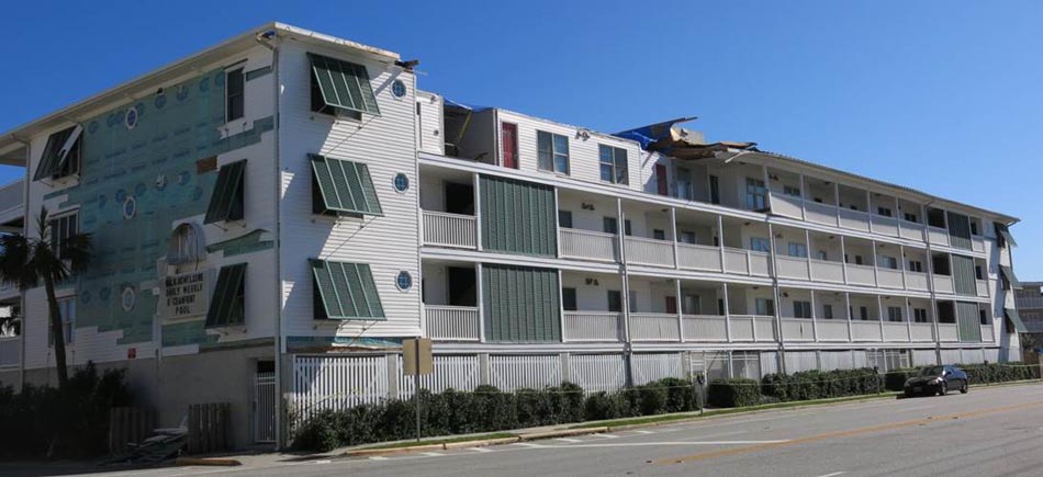 Significant wind damage to siding, soffit, and roof of a motel