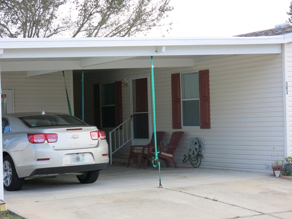 Ratchet tie down straps used to strengthen carports against uplift. Also, supporting beams add stiffness to the carport, which prevents buckling.