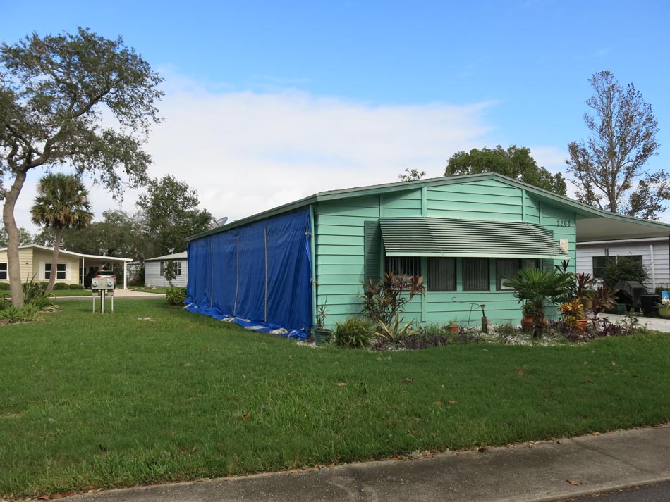 Wall siding covered with tarp to prevent further water damage.